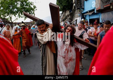 CARACAS, VENEZUELA - 16. APRIL: Katholische Gläubige reenact die Kreuzigung von Jesus Christus während einer Karfreitagsprozession in Caracas' Petare Shantytown, am 15. April 2022. (Foto von Pedro Mattey/PxImages) Stockfoto