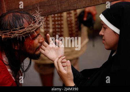 CARACAS, VENEZUELA - 16. APRIL: Katholische Gläubige reenact die Kreuzigung von Jesus Christus während einer Karfreitagsprozession in Caracas' Petare Shantytown, am 15. April 2022. (Foto von Pedro Mattey/PxImages) Stockfoto