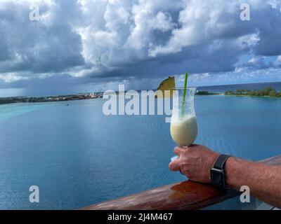 Nassau, Bahamas - 13. Oktober 2021: Ein Getränk für Erwachsene und Blick auf den Hafen des Kreuzschiffs mit Blick auf das türkisblaue Meer in Nassau, Bahamas ON Stockfoto