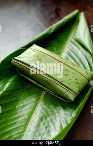 Traditionelle kolumbianische und mexikanische Gerichte aus Maisteig, gefüllt mit Huhn, Schweinefleisch, Schweinerippchen, Gemüse, eingewickelt in Bananenblätter. Tamal genannt. Stockfoto