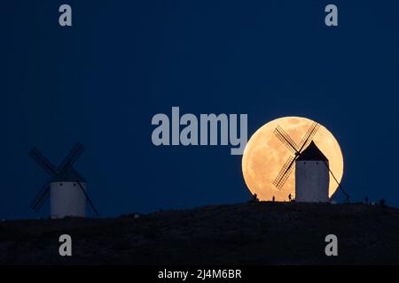 Consuegra, Spanien. 16. April 2022. Der Vollmond erhebt sich über einer Windmühle in Consuegra, Toledo. Der Vollmond im April, auch als Pink Moon bekannt, ist in diesem Jahr der erste Vollmond der Frühjahrssaison, was bedeutet, dass der Vollmond im April auch der Ostervollmond ist. Quelle: Marcos del Mazo/Alamy Live News Stockfoto