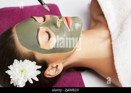 Frau mit Gesichtsmaske aus Lehm im Beauty Spa. Hautpflege. Schönheitskonzept. Close-up-Porträt des schönen Mädchen Anwendung Gesichtsmaske.Gesichtsbehandlung. Cosm Stockfoto