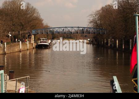 Ein Blick durch die Teddington Lock auf der Themse vom Deck eines Flusskreuzfahrtschiffes auf die Teddington Fußgängerbrücke Stockfoto