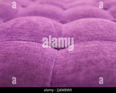 Polsterung aus Velours knöpfbarem violett-violettem Stoff, Wandmuster. Elegante Vintage gesteppte Sofa Hintergrund. Innen Stockfoto