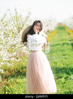 Frühlingsstil. Schöne Junge Brünette Frau Im Schönen Frühlingskleid. Wunderschöner Frühlingsgarten. Stockfoto