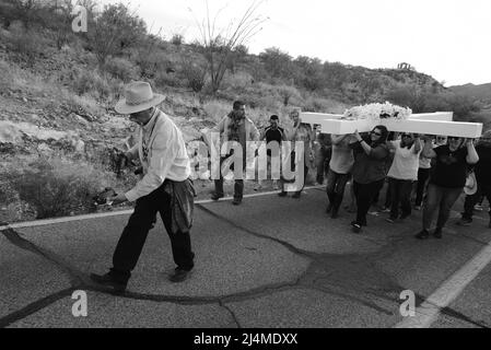 Tucson, Arizona, USA. 15. April 2022. Karfreitag Kreuzzug auf den Sentinal Peak in Tucson. Mehrere hundert Menschen tragen abwechselnd ein großes Holzkreuz auf den Gipfel Eines Berges. Es wird von der Dorados Ordan League gesponsert, die in einer Sonnenaufgangsmesse am Ostersonntag ihren Höhepunkt findet. Das jährliche Ereignis kehrte nach einer zweijährigen Pause aufgrund der Pandemie zurück. Der heilige Tohono O'odham führt die Prozession an. (Bild: © Christopher Brown/ZUMA Press Wire) Stockfoto