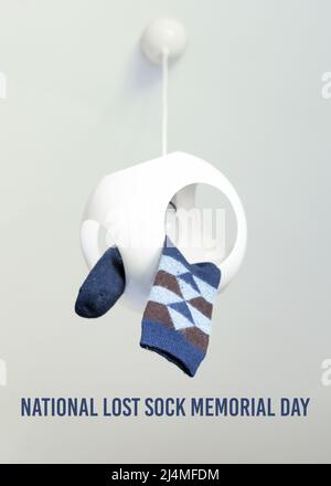 Eine Raute mit Karomuster hängt an einem Deckenleuchter. National Lost Sock Memorial Day Konzept. Stockfoto