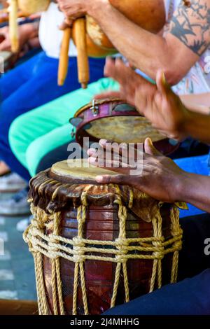 Perkussionist spielt ein rustikales und rudimentäres Perkursionsinstrument atabaque während einer afro-brasilianischen Kulturveranstaltung Stockfoto