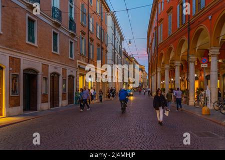 Modena, Italien, 22. September 2021: Blick auf eine Einkaufsstraße im Zentrum der italienischen Stadt Modena bei Sonnenuntergang. Stockfoto