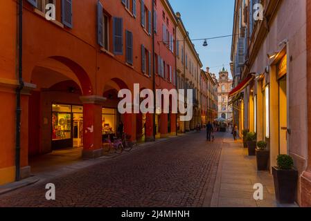 Modena, Italien, 22. September 2021: Blick bei Sonnenuntergang auf eine Straße, die zum Palazzo Ducale im Zentrum der italienischen Stadt Modena führt. Stockfoto