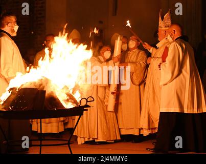 München, Deutschland. 16. April 2022. Vor dem Liebfrauendom zündet Kardinal Reinhard Marx (2. von rechts) vor dem Gottesdienst das Osterfeuer an. Quelle: Angelika Warmuth/dpa/Alamy Live News Stockfoto