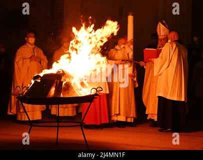 München, Deutschland. 16. April 2022. Vor dem Liebfrauendom zündet Kardinal Reinhard Marx (2. von rechts) vor dem Gottesdienst das Osterfeuer an. Quelle: Angelika Warmuth/dpa/Alamy Live News Stockfoto