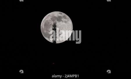 Super Vollmond hinter dem Stuttgarter Fernsehturm - die Antenne berührt den Mond. Stockfoto