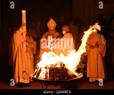 München, Deutschland. 16. April 2022. Vor dem Liebfrauendom zündet Kardinal Reinhard Marx (2. v.l.) vor dem Gottesdienst das Osterfeuer an. Quelle: Angelika Warmuth/dpa/Alamy Live News Stockfoto