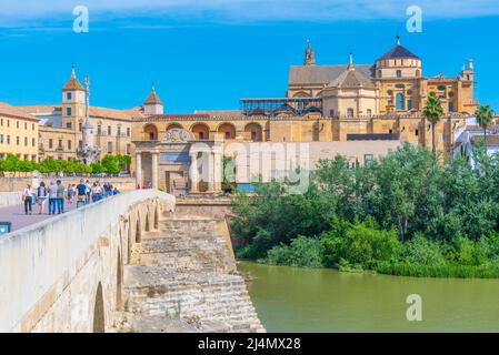Cordoba, Spanien, 25. Mai 2021: Die Menschen gehen über die römische Brücke in der spanischen Stadt cordoba in Richtung der Kathedrale La mezquita. Stockfoto