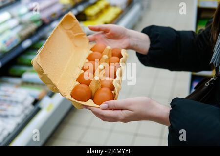 Frau wählt Hühnereier in einem Lebensmittelgeschäft. Nahaufnahme. Stockfoto