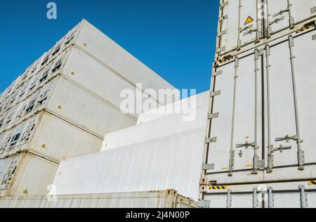 Gekühlte Versandbehälter, hoch gestapelt gegen einen blauen Himmel Stockfoto