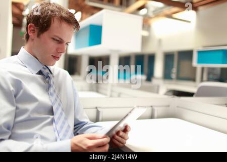 Junger professioneller Mann mit Tablet-Computer in offenen modernen Arbeitsbereich Stockfoto