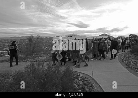 Tucson, Arizona, USA. 15. April 2022. Karfreitag Kreuzzug auf den Sentinal Peak in Tucson. Mehrere hundert Menschen tragen abwechselnd ein großes Holzkreuz auf den Gipfel Eines Berges. Es wird von der Dorados Ordan League gesponsert, die in einer Sonnenaufgangsmesse am Ostersonntag ihren Höhepunkt findet. Das jährliche Ereignis kehrte nach einer zweijährigen Pause aufgrund der Pandemie zurück. (Bild: © Christopher Brown/ZUMA Press Wire) Stockfoto