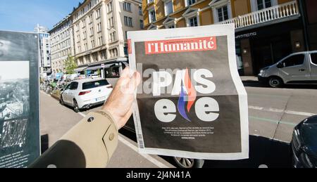 Paris, Frankreich - 11. Apr: Mann in der Stadt die französische l'Humanite Zeitung Emmanuel Macron, Marine Le Pen einen Tag nach der ersten Runde der französischen Präsidentschaftswahlen am 10 2022. April - kippen Sie vorbei Stockfoto