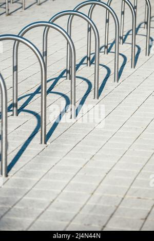 Mehrere aus Edelstahl gesicherte leere Fahrradständer stehen leer, um Fahrräder im städtischen Stadtgebiet zu parken Stockfoto