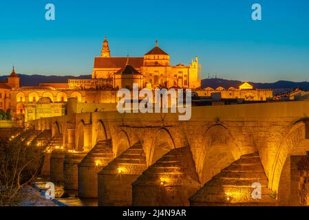 Sonnenuntergang über der alten römischen Brücke in der spanischen Stadt cordoba mit der Kathedrale La mezquita am Horizont Stockfoto