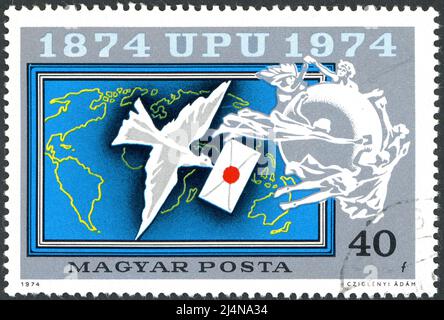 Die in Ungarn gedruckte Briefmarke, die dem 100.-jährigen Bestehen der Universal Postal Union (UPU) gewidmet ist, zeigt die Brieftaube, um 1974 Stockfoto