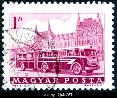 UNGARN - UM 1963: Eine in Ungarn gedruckte Briefmarke, abgebildet Bus und Parlament, Budapest, um 1963 Stockfoto