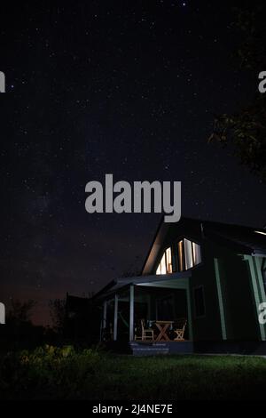 Landhaus unter Sternenhimmel bei Nacht Stockfoto