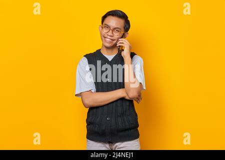 Porträt eines attraktiven asiatischen Mannes, der auf dem Smartphone spricht und glücklich aussieht Stockfoto