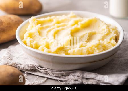 Kartoffelpüree in weißer Schüssel auf grauem Betongrund. Gesunde Ernährung Stockfoto