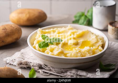 Kartoffelpüree in weißer Schüssel auf grauem Betongrund. Gesunde Ernährung Stockfoto