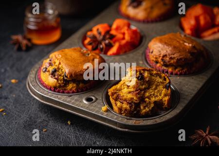 Hausgemachte würzige Kürbismuffins oder Cupcakes mit Schokolade auf einem Metallgestell. Herbstlicher Nachtisch. Selektiver Fokus Stockfoto