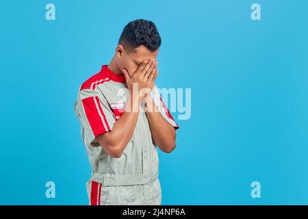 Porträt des jungen Mechanikers flehen und beten mit Händen zusammen mit Ausdruck der Hoffnung auf Gesicht sehr emotional und besorgt Stockfoto