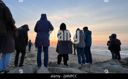 Bournemouth, Großbritannien. 17.. April 2022. Christen aus der St. Andrew's Church in Kinson, Bournemouth, versammeln sich am Strand von Branksome Chine, Dorset, zu einem Sonnenaufgangsgottesdienst am Ostertag. Aufgrund der Pandemie konnte diese in den letzten zwei Jahren nicht mehr gehalten werden. Kredit : Richard Crease / Alamy Live Nachrichten Stockfoto