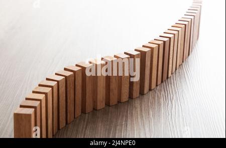 Eine Menge Holzklotz, der in einer Linie steht. Domino-Effekt-Konzept Stockfoto