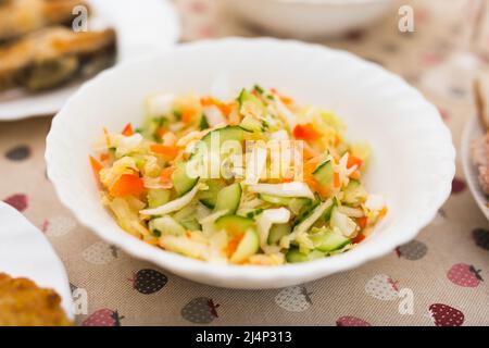 Gehackter Kohl, Tomaten, Gurken, Zwiebeln und Kräuter in einer Schüssel Stockfoto