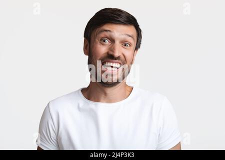 Kopfschuss Eines Verwirrten Bartmenschen, Der Die Schultern Über Weißem Hintergrund Zuckt Stockfoto