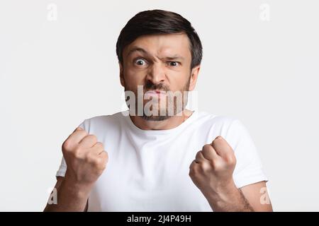 Wütender Mann, Der Fäuste Zusammenhält Bereit, Um Über Weißen Hintergrund Zu Kämpfen Stockfoto