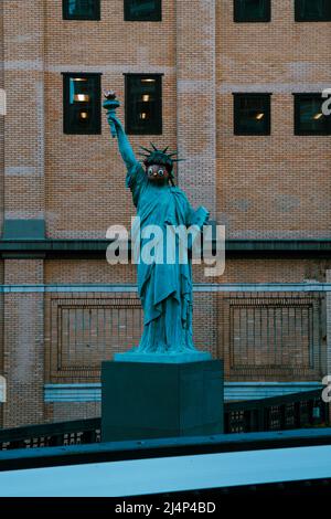 Die Freiheitsstatue mit einer von Emoji inspirierten Maske namens ‘You Know Who I am’ von paola pivi erhebt sich in New York City Stockfoto