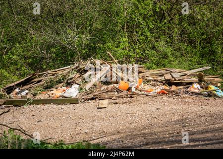 Illegale Fliegenkippen Abfälle von entfernten Zaunplatten, Schutt und Beton auf einem Landweg Stockfoto