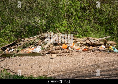 Illegale Fliegenkippen Abfälle von entfernten Zaunplatten, Schutt und Beton auf einem Landweg Stockfoto