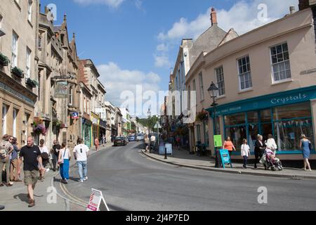 Blick auf die Einkaufsbummel auf der High Street in Glastonbury, Somerset, Großbritannien Stockfoto