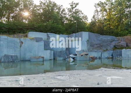 Granitbruch mit großen Granitblöcken verlassene Granitbrüche mit Regenwasser. Granitabbau in einem Steinbruch. Stockfoto