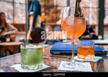 Orangefarbene und grüne Getränke in Gläsern auf dem Tisch des Restaurants im Resort Stockfoto