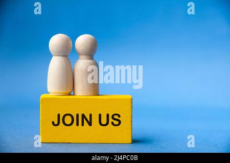 Holzpuppen auf gelbem Holzblock mit Text begleiten uns. Business- und Online-Konzept Stockfoto