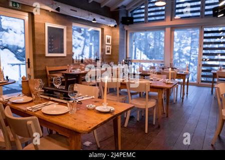 Brennende Kerzen auf den Esstischen im beleuchteten Restaurant des luxuriösen Resorts Stockfoto