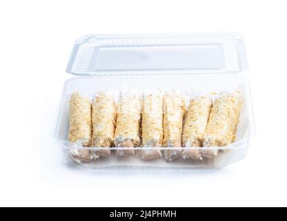 Schuppige süße Brötchen mit Creme in Plastikverpackung isoliert auf weiß Stockfoto