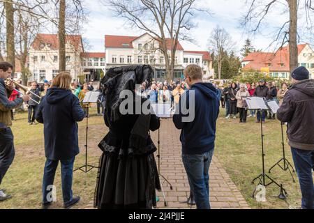 Burg, Deutschland. 17. April 2022. Am Ostersonntag stehen Mitglieder des Posaunenchors der Kirchengemeinde Burg vor der evangelischen Kirche im Spreewald Burg. Der Ostergottesdienst wird hier stattfinden. Der traditionelle Ostergesang findet in diesem Jahr nicht statt, weil es aufgrund der Korona keine Gelegenheit gab, zu Proben. Während des Gottesdienstes tragen die Spreewald-Frauen zum einzigen Mal im ganzen Jahr ihre ganz schwarzen Trachten. Quelle: Frank Hammerschmidt/dpa/Alamy Live News Stockfoto