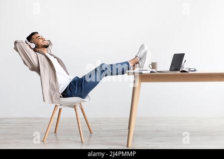 Asiatischer Mann, der mit Kopfhörern Musik hört Stockfoto